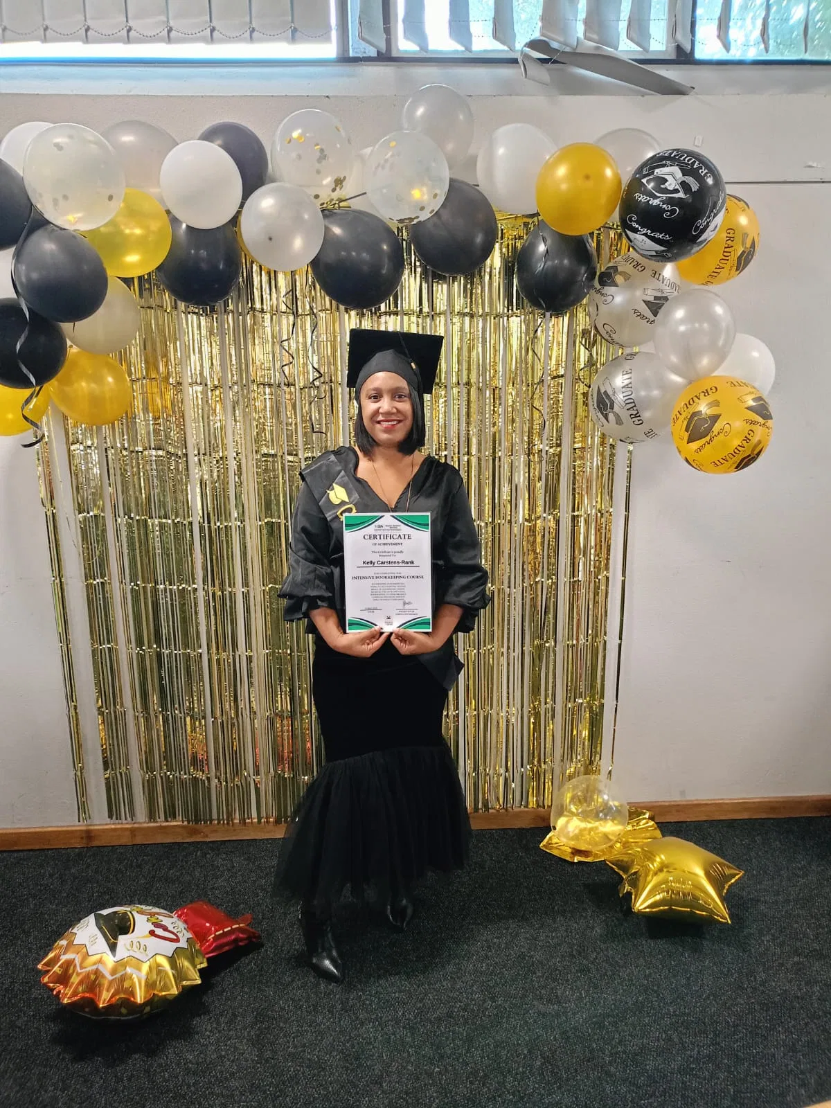 Kelly Carstens-Rank holding her certificate of achievement for an intensive bookkeeping course